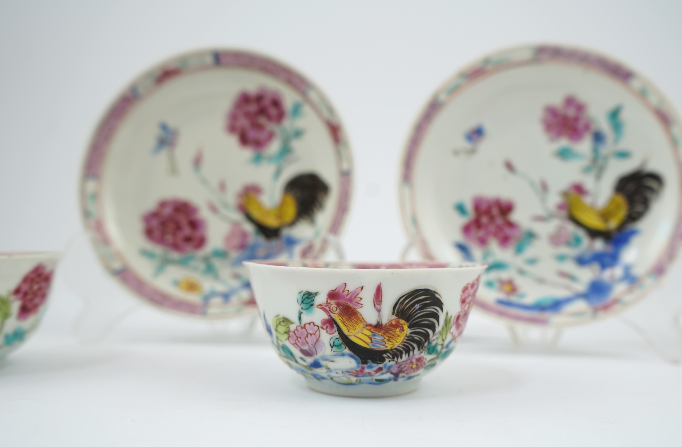 A near pair of Chinese famille rose ‘cockerel’ tea bowls and saucers, Yongzheng period